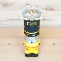 6-inch round clear acrylic router base plate attached to yellow DeWalt trim router, shown from above on wood workbench