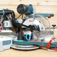 Black ToolCurve 2-1/2 inch hose adapter with blue ring resting on a Bosch 10-inch glide miter saw table