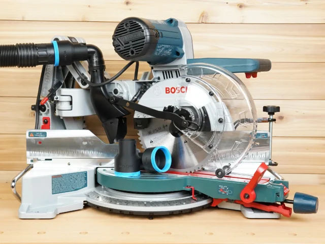 Black ToolCurve 2-1/2 inch hose adapter with blue ring resting on a Bosch 10-inch glide miter saw table