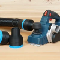 Black 2-1/2 inch hose adapter with blue trim ring, one connected to a hose beside a Bosch PL2632 planer