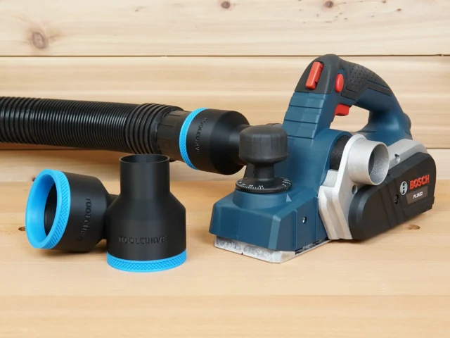 Black 2-1/2 inch hose adapter with blue trim ring, one connected to a hose beside a Bosch PL2632 planer
