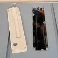 Zero clearance insert for Ridgid R4513 table saw shown front and back; cream-colored MDF face with rectangular recess and mounting holes, black interior with metal hardware visible