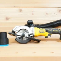 Black ToolCurve 2-1/2 inch hose adapter with blue trim beside a DeWalt Atomic 20V circular saw with hose attached
