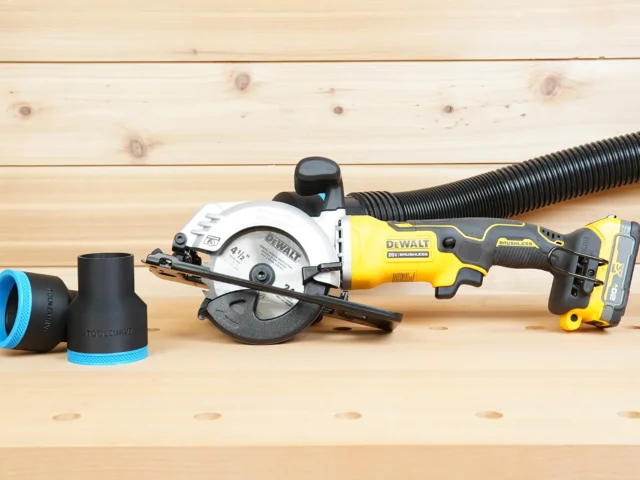 Black ToolCurve 2-1/2 inch hose adapter with blue trim beside a DeWalt Atomic 20V circular saw with hose attached
