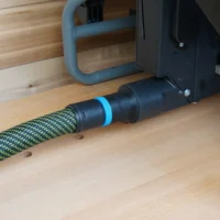 Black 36mm hose adapter joining a green braided extractor hose to a Craftsman table saw dust port
