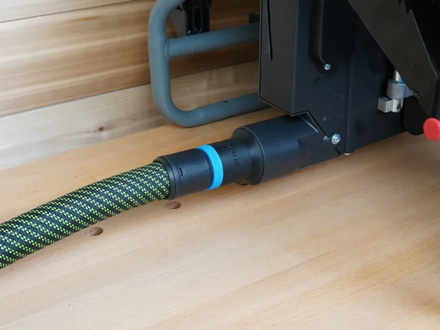 Black 36mm hose adapter joining a green braided extractor hose to a Craftsman table saw dust port