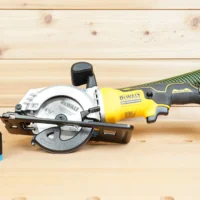 Black ToolCurve 36mm hose adapter with blue ribbed end standing beside a DeWalt Atomic 4-1/2 in. circular saw