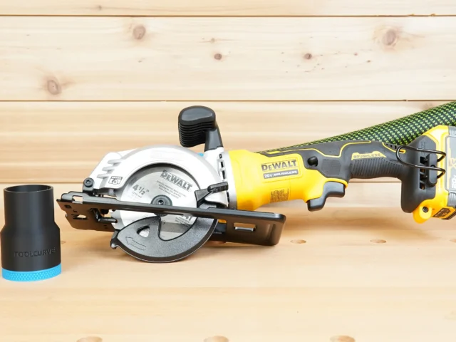 Black ToolCurve 36mm hose adapter with blue ribbed end standing beside a DeWalt Atomic 4-1/2 in. circular saw