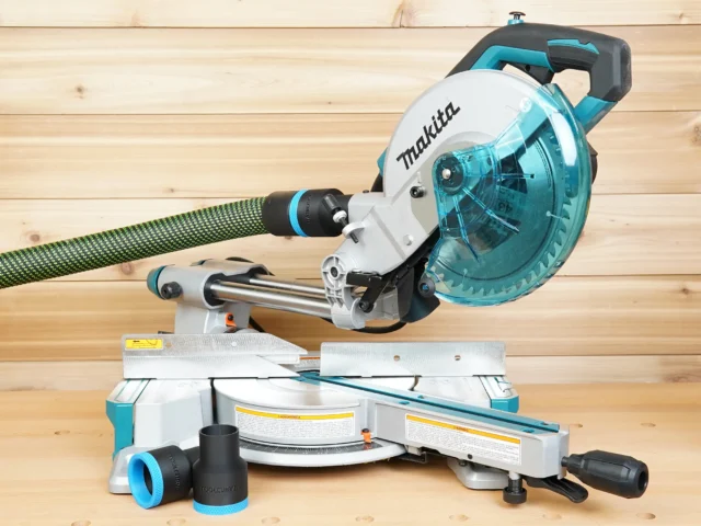 Black 36mm hose adapter installed on a Makita LS miter saw dust port with green hose, plus a spare adapter alongside