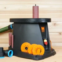 Black 36mm hose adapter with blue ring beside a WEN oscillating spindle sander connected to a green hose