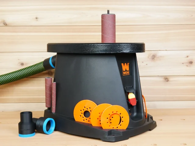 Black 36mm hose adapter with blue ring beside a WEN oscillating spindle sander connected to a green hose