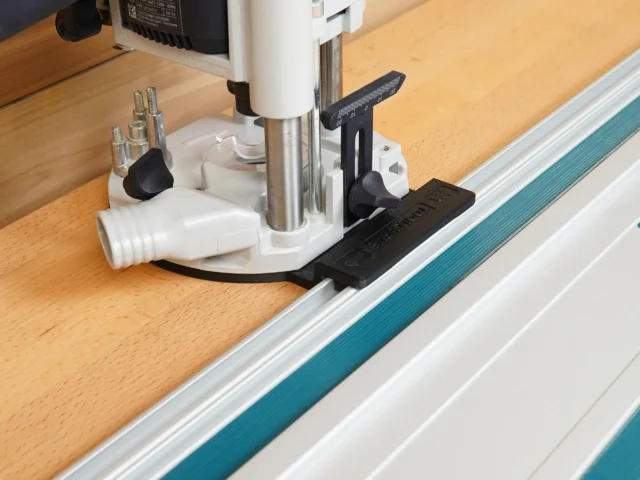 Guide Rail Adapter for OF 1010 Router mounted on Festool track saw guide rail, showing black adapter plate and white base with adjustment knobs