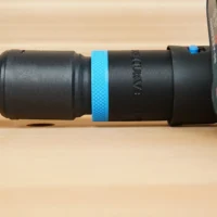 Hose adapter attached to Bosch planer outlet with blue band around connection, green and yellow braided hose visible on left