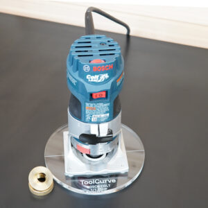 6-inch round clear acrylic base plate mounted on a Bosch Colt 1 HP router, with a brass guide bushing shown separately on the left