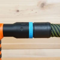 Blue hose adapter attached to WEN handheld spindle sander with green braided hose connected on the right side