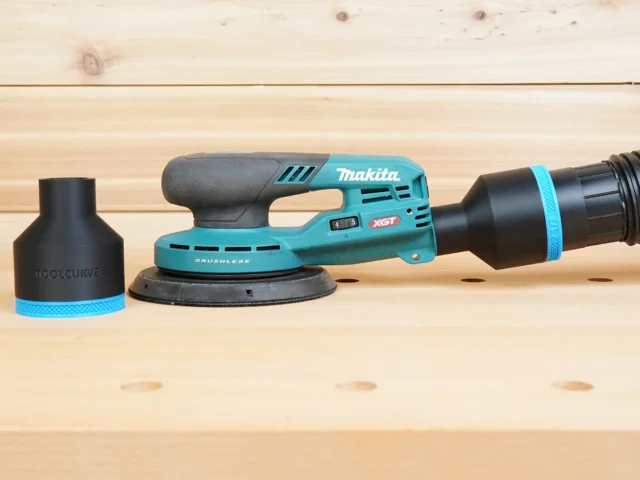 Black 2-1/2 inch hose adapter with blue band installed on a Makita XGT sander, second adapter beside it
