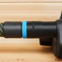Black plastic hose adapter with blue band installed on Bosch Planer, connected to yellow and black braided hose