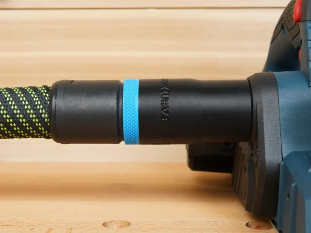 Black plastic hose adapter with blue band installed on Bosch Planer, connected to yellow and black braided hose