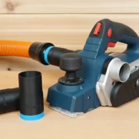 Black 1-1/4 inch hose adapter with blue collar beside a Bosch PL2632 planer, orange hose attached above