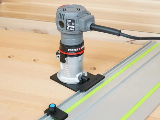 Porter Cable trim router mounted on black rail adapter, positioned over Festool guide rail on wooden workbench