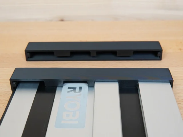 Black PETG protective caps for Ryobi guide rail, one cap installed on rail end and one cap shown separately