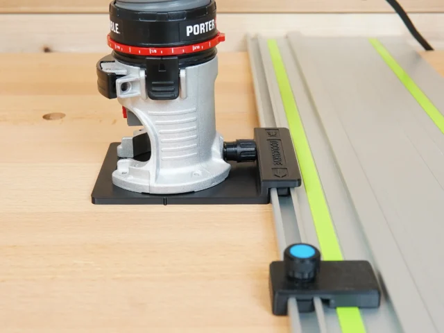ToolCurve Porter Cable trim router rail adapter mounted on router base plate and attached to a guide rail on wood
