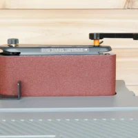 Ridgid oscillating sander wrench with red sandpaper-wrapped sleeve mounted on sander adjustment knob, shown from front angle