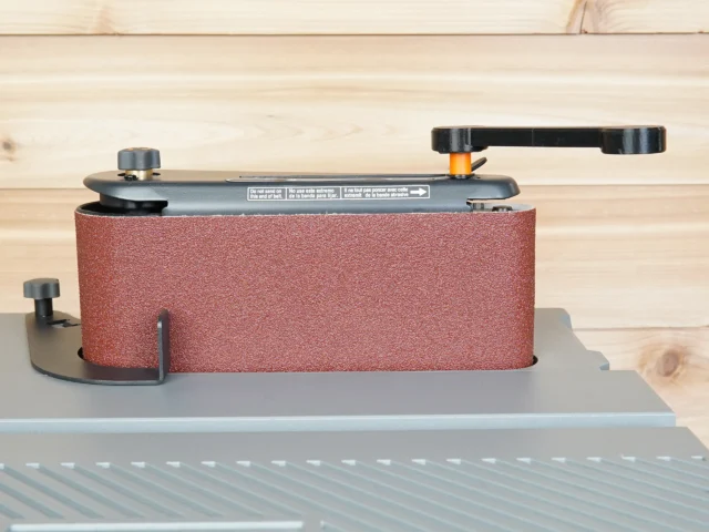 Ridgid oscillating sander wrench with red sandpaper-wrapped sleeve mounted on sander adjustment knob, shown from front angle