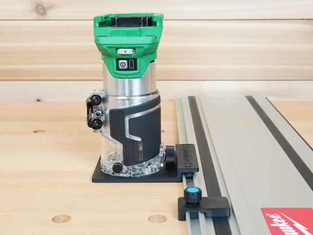 Metabo HPT trim router mounted on black rail adapter connected to Festool track saw guide rail, shown on workbench