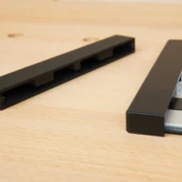 Two black protective caps shown separately and one installed on an aluminum Ryobi track saw rail, displaying the friction-fit design