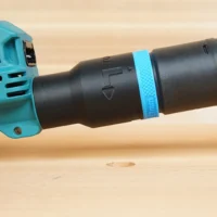 Black hose adapter with blue band attached to Makita 40v XGT sander dust port, shown from the side