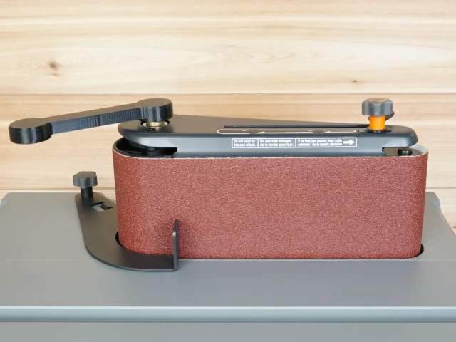 Ridgid oscillating sander wrench with black metal handle and orange knob, mounted on a gray track showing the wrench gripping the adjustment knob
