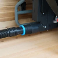Black 1-7/8 inch hose adapter with blue collar joining a vacuum hose to a Craftsman table saw dust port