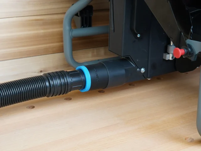 Black 1-7/8 inch hose adapter with blue collar joining a vacuum hose to a Craftsman table saw dust port