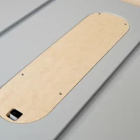 Birch zero clearance insert for SawStop table saw, showing rounded end with mounting holes and recessed blade slot