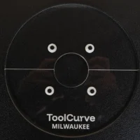 Black acrylic circular router base plate with center hole and four mounting holes, labeled ToolCurve Milwaukee