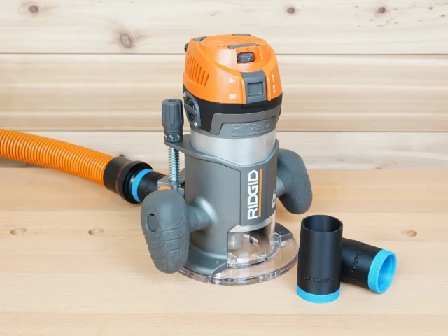 Ridgid 2 HP fixed base router with orange hose attached, plus two black ToolCurve 1-1/4" hose adapters beside it