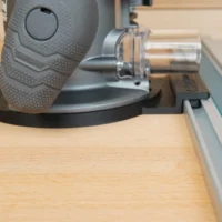 Ridgid 2 HP router attached to a Festool guide rail via black adapter base, mounted on wooden workbench