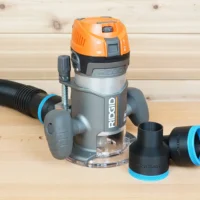 Two black ToolCurve 2-1/2 inch hose adapters with blue rings beside a Ridgid 2 HP fixed base router and hose