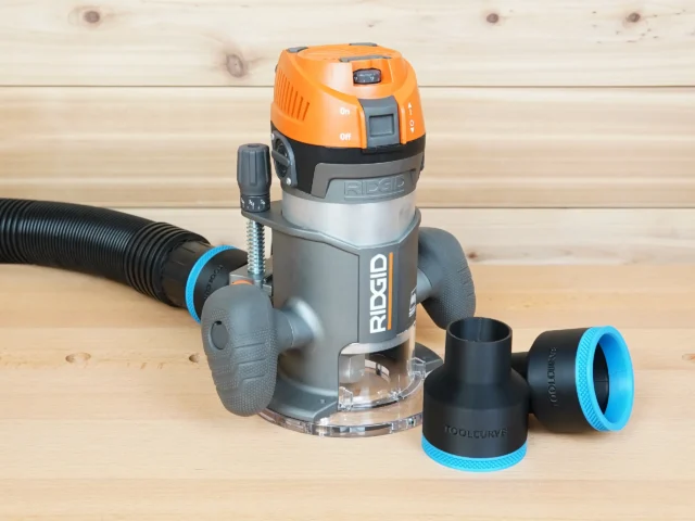 Two black ToolCurve 2-1/2 inch hose adapters with blue rings beside a Ridgid 2 HP fixed base router and hose