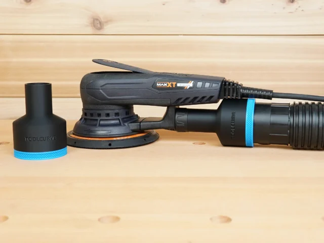Black ToolCurve 2-1/2 inch hose adapter with blue band beside a MAXXT sander with a second adapter fitted to its rear dust port
