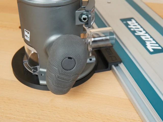 Gray 3D-printed guide rail adapter mounted on a Ridgid 2 HP router base, shown attached to a Makita guide rail