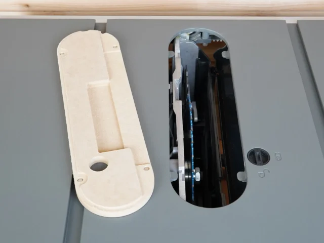 Zero clearance insert for Hercules 10" table saw shown from above, natural MDF finish on left, black insert mounted in saw on right