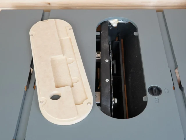 Zero clearance insert for Craftsman CMX 10" table saw, cream-colored MDF body shown next to black original insert to compare fit and construction