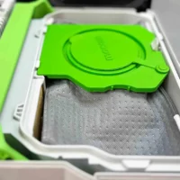 Green lid open on reusable Macam dust bag with gray three-layer polyester fleece, inside white plastic container for Festool CTL SYS extractors