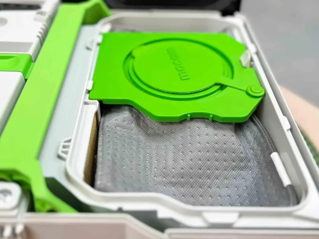 Green lid open on reusable Macam dust bag with gray three-layer polyester fleece, inside white plastic container for Festool CTL SYS extractors