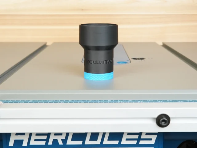 Black cylindrical hose adapter with blue grip band, mounted on a Hercules table saw dust port