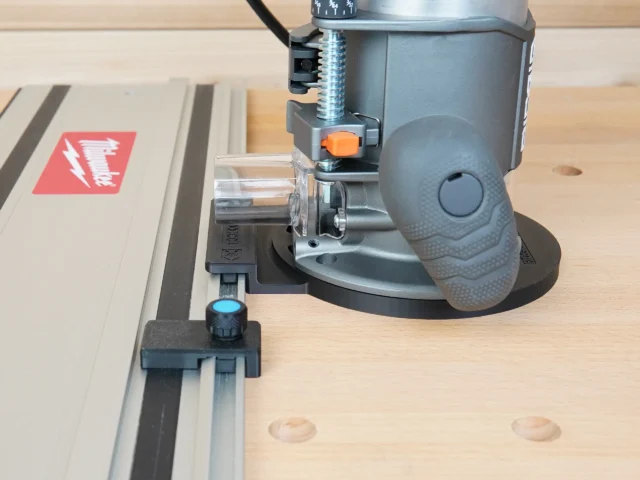 Guide rail adapter mounted on a Ridgid 2 HP router, attached to a Festool track saw rail on a wooden workbench