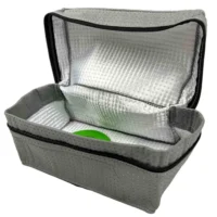 Gray polyester reusable dust bag with black zipper and silver reflective inner lining, shown open with a green object inside