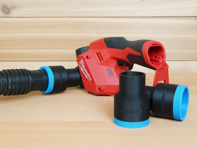 Black ToolCurve 1-7/8 inch hose adapters with blue rings, one joined to a vac hose beside a red Milwaukee M12 planer